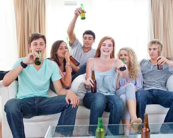 Young friends drinking beer and watching tv at home