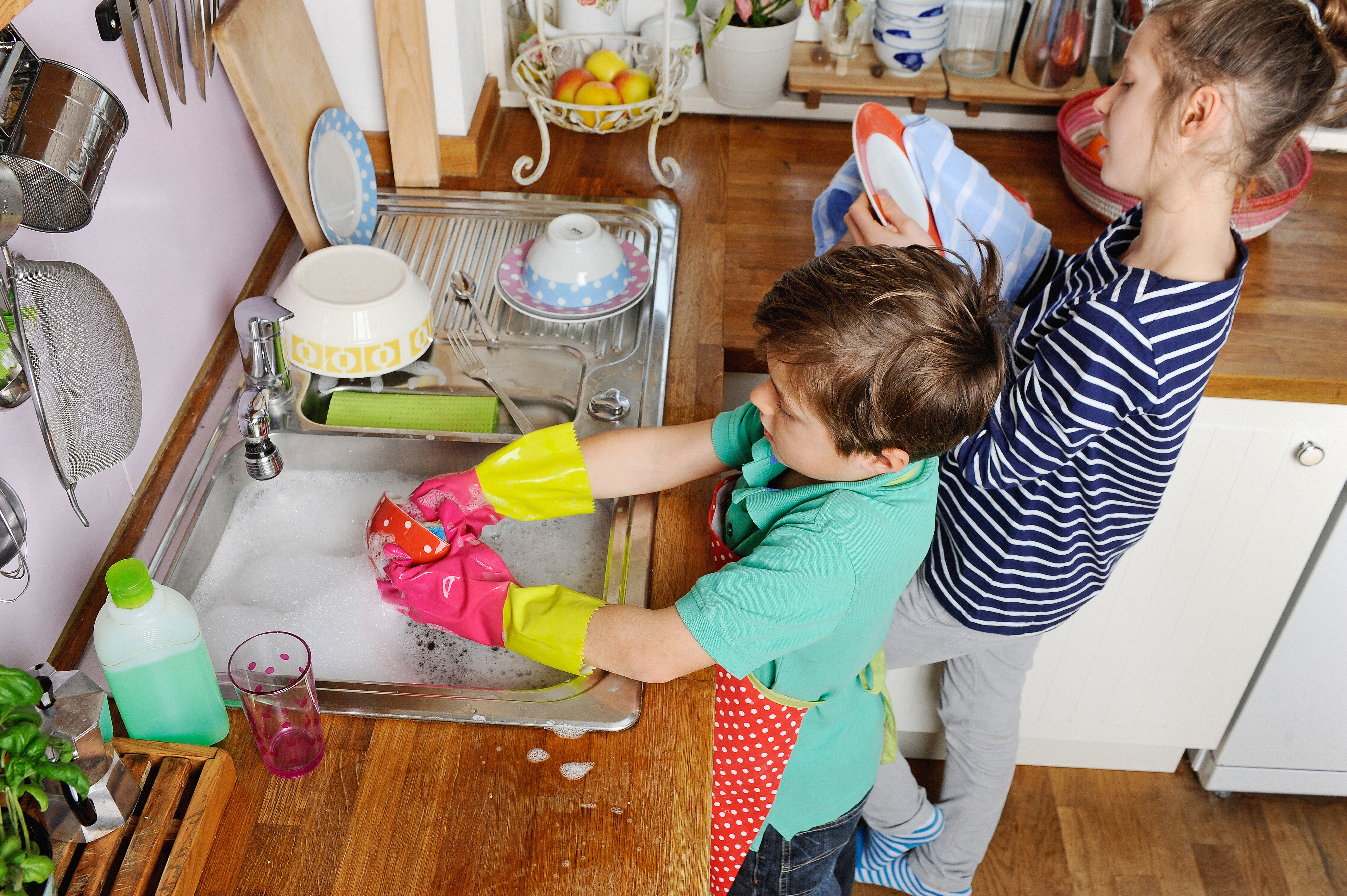 Семья моет посуду. Дети помогают родителям. Ребенок наводит порядок. Ребенок убирается. Дети убирают в доме.